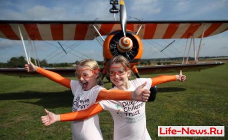 Две 9-летние девочки совершили полёт, стоя на крыльях бипланов 